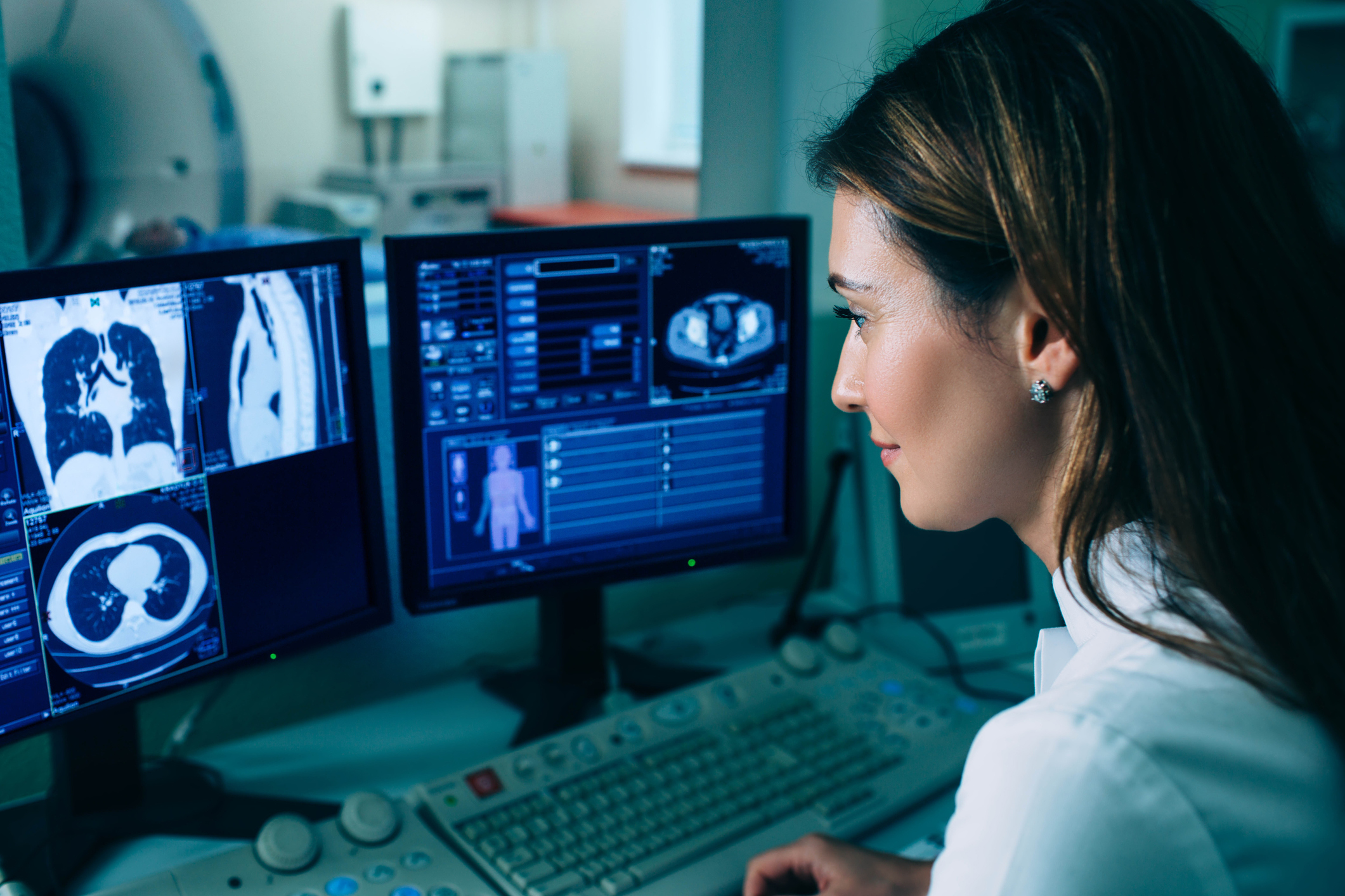 Radiologist reading a CT scan from control room at hospital